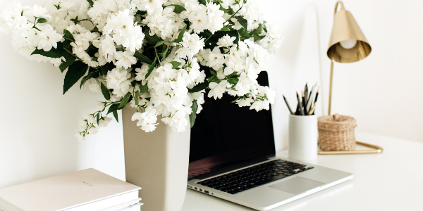 flower vase on desk next to laptop